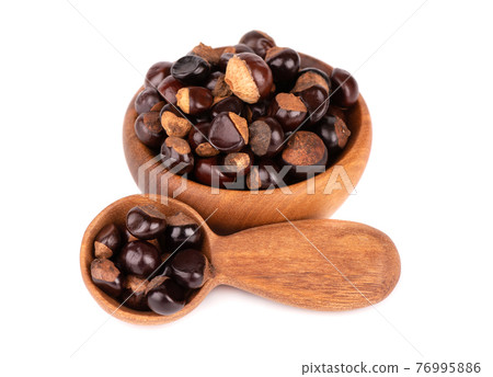 Guarana seed in wooden bowl and spoon, isolated on white background. Dietary supplement guarana, caffeine cource for energy drinks. 76995886