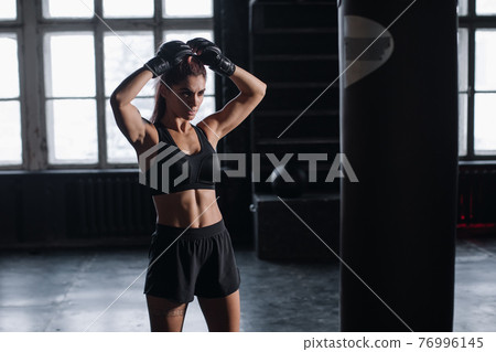 young girl stands in an atmospheric fitness room against the background of lockers for changing room 76996145