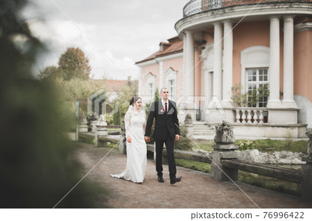 Amazing happy gentle stylish beautiful romantic caucasian couple on the background ancient baroque castle Amazing happy gentle stylish beautiful romantic caucasian couple on the background ancient baroque castle 76996422