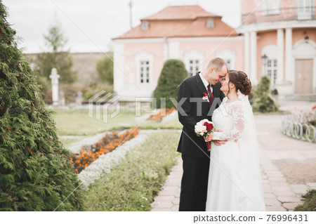 Amazing happy gentle stylish beautiful romantic caucasian couple on the background ancient baroque castle Amazing happy gentle stylish beautiful romantic caucasian couple on the background ancient baroque castle 76996431