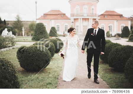 Amazing happy gentle stylish beautiful romantic caucasian couple on the background ancient baroque castle Amazing happy gentle stylish beautiful romantic caucasian couple on the background ancient baroque castle 76996436