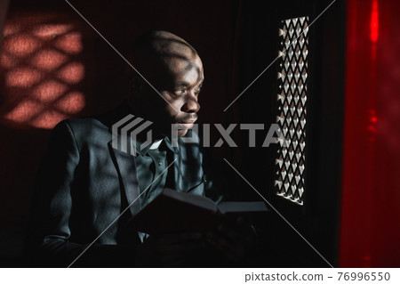 Priest reading the Bible in the church Priest reading the Bible in the church 76996550
