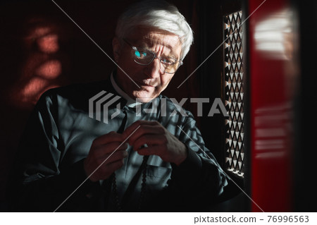 Priest with rosary listening to confession Priest with rosary listening to confession 76996563