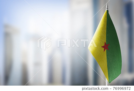 A small flag of French Guiana on the background of a blurred background A small flag of French Guiana on the background of a blurred background 76996972