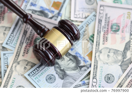 On table are American bills with a judge's wooden gavel. 76997900