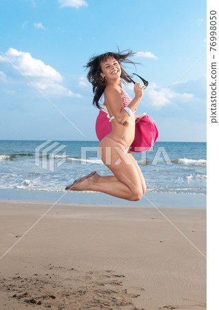 pretty young woman in bikini on the seashore at the beach 76998050