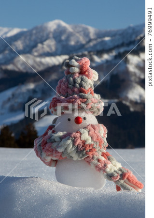 Snowman Snowfield, snowy mountains and blue sky background 76999491