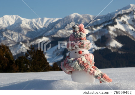 Snowman Snowfield, snowy mountains and blue sky background 76999492