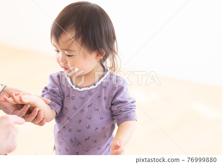 媽媽給她的孩子塗上保濕霜 76999880