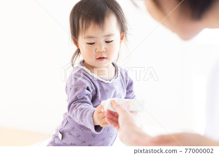媽媽給她的孩子塗上保濕霜 77000002