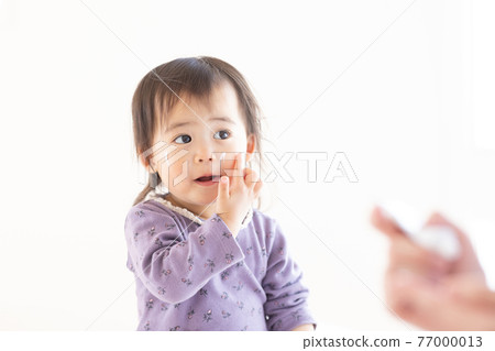 媽媽給她的孩子塗上保濕霜 77000013