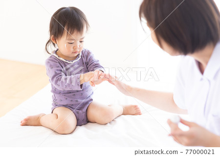 媽媽給她的孩子塗上保濕霜 77000021