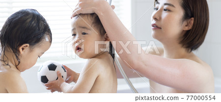 Twin toddlers and mom taking a bath Twin toddlers and mom taking a bath 77000554