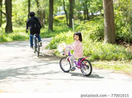 Parents and children enjoying cycling 77001015