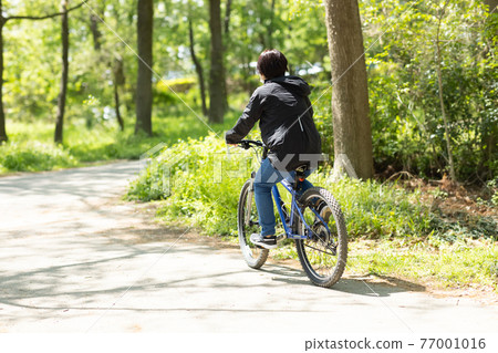 Woman enjoying a bicycle 77001016