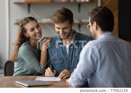 Excited couple sign document closing deal at meeting 77002226