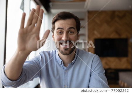 Portrait of smiling man wave talking on video call Portrait of smiling man wave talking on video call 77002252