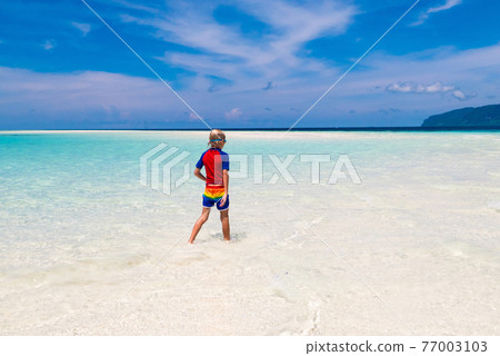 Kids playing on beach. Children play at sea. 77003103