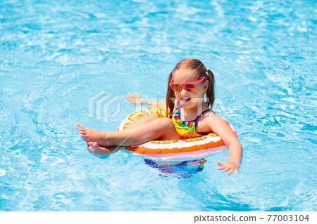 Child in swimming pool on toy ring. Kids swim. Child in swimming pool on toy ring. Kids swim. 77003104