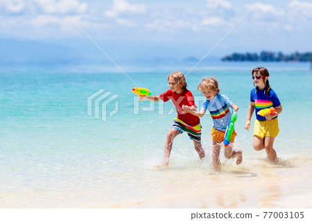 Child with toy water gun. Kids vacation beach fun. Child with toy water gun. Kids vacation beach fun. 77003105
