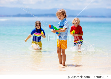 Child with toy water gun. Kids vacation beach fun. Child with toy water gun. Kids vacation beach fun. 77003106