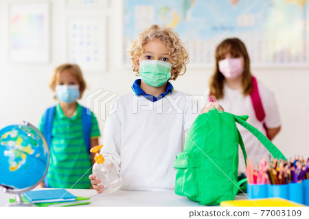 Hand sanitizer in school. Child in face mask. 77003109