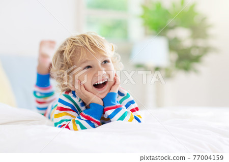 Child playing in bed. Kids room. Baby boy at home. Child playing in bed. Kids room. Baby boy at home. 77004159