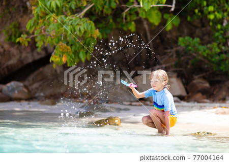 Kids playing on beach. Children play at sea. 77004164