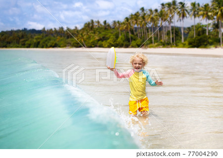Child on tropical beach. Sea vacation with kids. 77004290