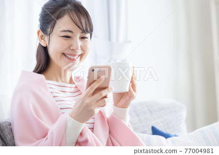 Lifestyle young woman looking at a smartphone 77004981