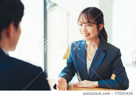 一個穿西裝的女人為顧客服務 一個穿西裝的女人為顧客服務 77005426