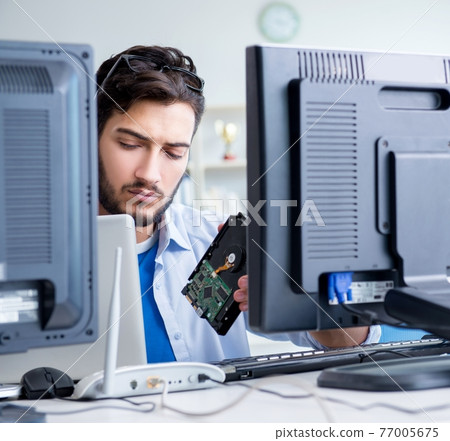 IT technician looking at IT equipment 77005675