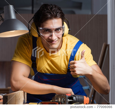Worker working in repair workshop in woodworking concept 77006066