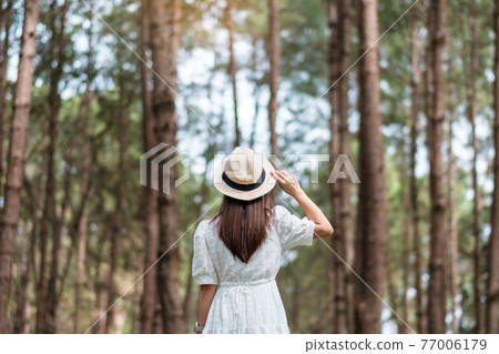 Happy traveler woman standing and looking Pine tree forest, solo tourist in white dress and hat traveling at Pang Oung, Mae Hong Son, Thailand. travel, trip and vacation concept Happy traveler woman standing and looking Pine tree forest, solo tourist in white dress and hat traveling at Pang Oung, Mae Hong Son, Thailand. travel, trip and vacation concept 77006179