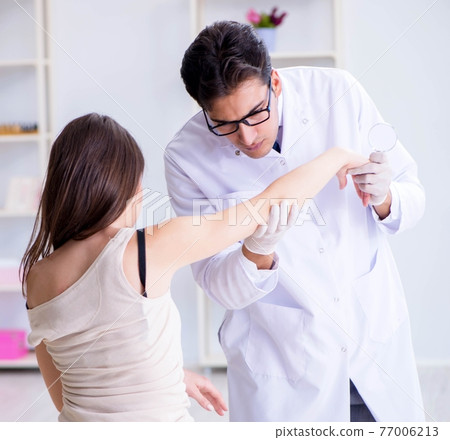 Doctor examining the skin of female patient Doctor examining the skin of female patient 77006213
