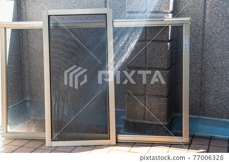 Cleaning screen doors dirty with pollen on a sunny day 77006328