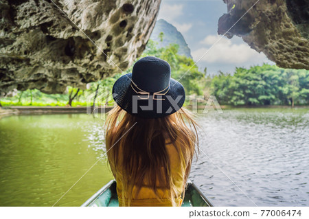 Woman tourist in boat on the lake Tam Coc, Ninh Binh, Viet nam. It's is UNESCO World Heritage Site, renowned for its boat cave tours. It's Halong Bay on land of Vietnam. Vietnam reopens borders after Woman tourist in boat on the lake Tam Coc, Ninh Binh, Viet nam. It's is UNESCO World Heritage Site, renowned for its boat cave tours. It's Halong Bay on land of Vietnam. Vietnam reopens borders after 77006474