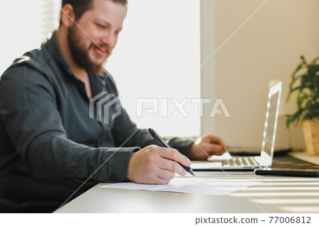Office worker working with documents and using laptop. Office worker working with documents and using laptop. 77006812