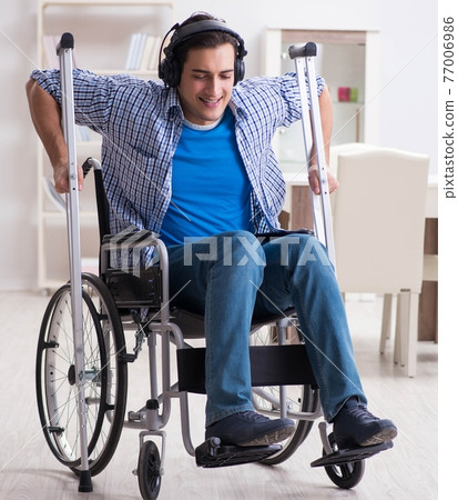 Disabled man listening to music in wheelchair Disabled man listening to music in wheelchair 77006986