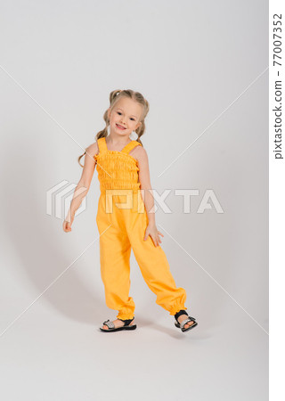 Portrait of a cheerful girl jumping and dancing against a studio background Portrait of a cheerful girl jumping and dancing against a studio background 77007352