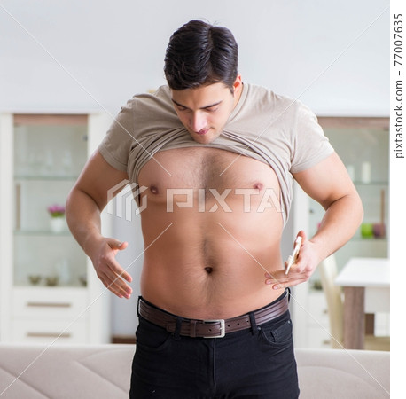 Man Is Measuring His Body Fat With Calipers Stock Photo - Download