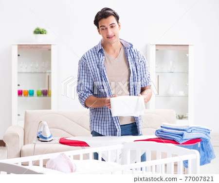 Young dad looking after newborn baby Young dad looking after newborn baby 77007821