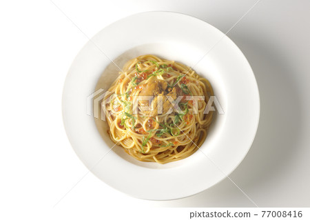A steaming sea urchin cream sauce pasta with raw sea urchin and salmon roe on a white background (overhead view) 77008416