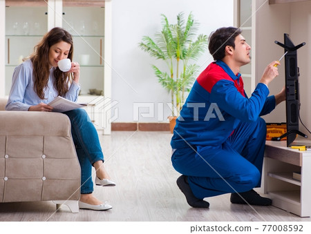 Repairman repairing tv at home Repairman repairing tv at home 77008592