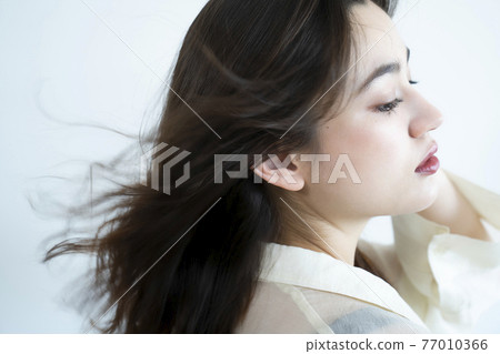 Beauty portrait of a woman with fluttering hair Beauty portrait of a woman with fluttering hair 77010366