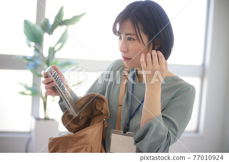 A female employee whose remote control came out of her bag 77010924