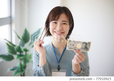 Female employee with 1000 yen bill and chopsticks 1000 yen lunch image 77010925