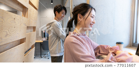 Banner size of a young woman standing in a coworking space and working on a computer Banner size of a young woman standing in a coworking space and working on a computer 77011607