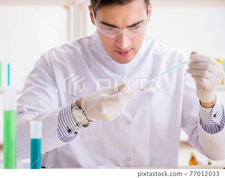 Young chemist student working in lab on chemicals Young chemist student working in lab on chemicals 77012033