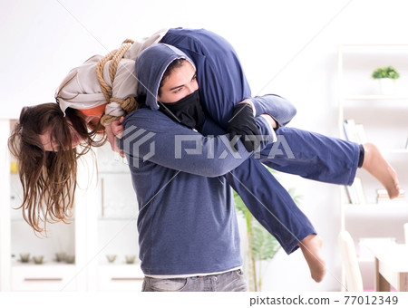 Armed man assaulting young woman at home Armed man assaulting young woman at home 77012349